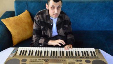 Engelli müzisyen Murat Coşkun, koltukta oturarak org çalıyor.