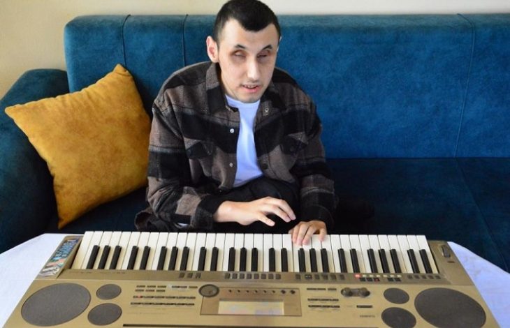 Engelli müzisyen Murat Coşkun, koltukta oturarak org çalıyor.