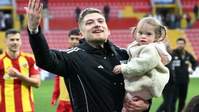 Futbolcu Semih Güler, kızı Defne'yi kucağında tutarak maç sonu galibiyetini kutluyor.