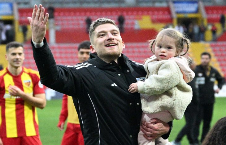 Futbolcu Semih Güler, kızı Defne'yi kucağında tutarak maç sonu galibiyetini kutluyor.