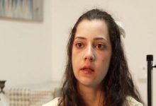 Görselde, genç bir kadın yakın planda görülüyor. Yüz ifadesi yorgun ve sakin; arka planda iç mekâna ait, nötr tonlarda bir ortam bulunuyor. Kadının saçları omuzlarına dökülmüş, başında açık renkli bir toka yer alıyor. Kare, kişinin anlatıma dayalı bir röportaj ya da haber konusu içinde yer aldığını düşündüren bir portre niteliği taşıyor.