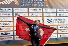 Milli Özel Sporcumuz Aysel Önder, sırtında tuttuğu Türk bayrağı ile beraber poz veriyor.