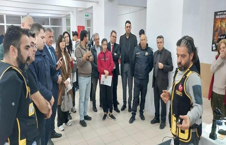 Afet eğitimi veren yetkiliyi dinleyen okul görevlileri ve öğrenciler.