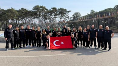 Para Yüzme Dünya Serisi'ne katılan milli sporcular ile teknik heyet, açık bir alanda süs havuzu önünde Türk bayrağı açarak poz veriyor.