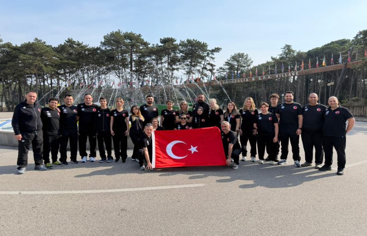 Para Yüzme Dünya Serisi'ne katılan milli sporcular ile teknik heyet, açık bir alanda süs havuzu önünde Türk bayrağı açarak poz veriyor.