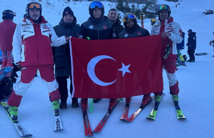 Otizm Kayak Milli Takımımız ve antrenörler Türk bayrağı açarak yarışma alanında poz veriyor.