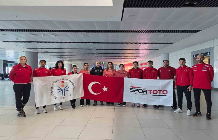 Özel Sporcular Para Atletizm Milli Takımı, teknik kadro ile TÖSSFED ve Spor Toto logolu bayrağı tutuyorlar.