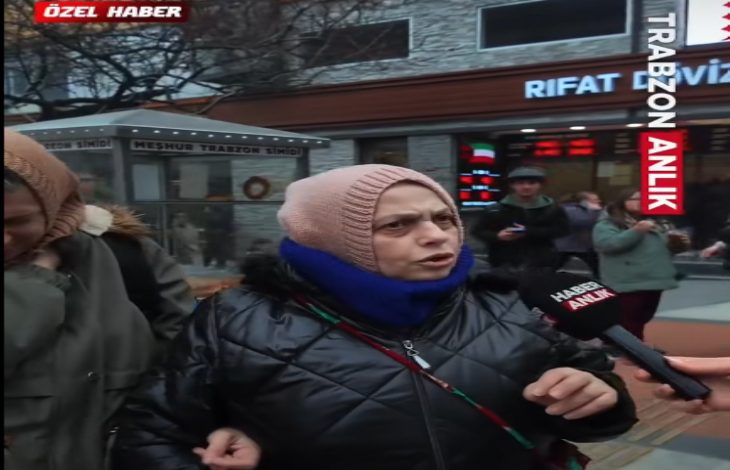 Bir sokakta çekilen görüntüde, başörtülü bir kadın mikrofon uzatılmış şekilde konuşurken görülüyor. Üzerinde mont ve atkı bulunan kadın ciddi bir ifadeyle konuşuyor. Arka planda insanlar, dükkânlar dikkat çekiyor; görüntü bir haber röportajına ait.