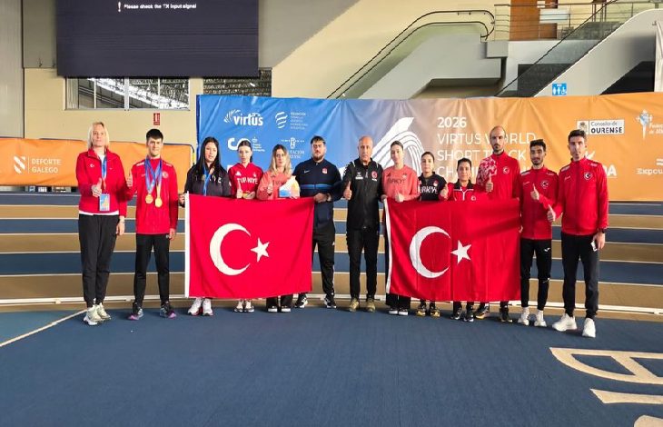 Fotoğrafta kapalı bir spor salonunda toplu halde poz veren sporcular ve antrenörler görülüyor. Sporcuların çoğu kırmızı Türkiye yazılı eşofmanlar giymiş. Grubun ortasında iki kişi büyük Türk bayrakları tutuyor. Bazı sporcuların boynunda kazandıkları madalyalar bulunuyor. Arka planda “2026 Virtus World Short Track Championship” yazılı bir organizasyon panosu yer alırken, sporcular ve teknik ekip kamera karşısında takım halinde gururla poz veriyor.