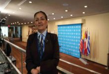 Milletvekili Fatma Öncü, toplantı salonunda ayakta durarak poz veriyor.