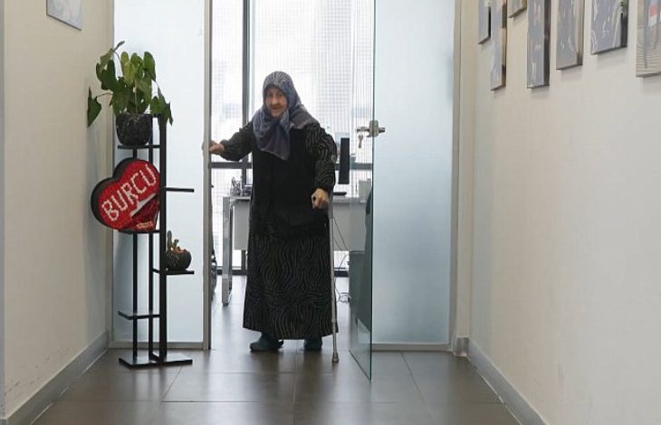 Fil hastalığı nedeniyle yürüyemez hale gelen Hava Mutlu, hastane koridorunda değnek tutarak yürüyor.