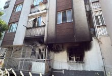 Alt katında yangın çıkmış bir apartmanın dış cephesinde, pencerelerin etrafında yoğun is ve kararma izleri görülüyor.