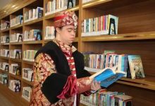 Down sendromlu bir genç, bir kitaplıktan seçtiği kitabı dikkatle incelerken görülüyor. Üzerinde, Osmanlı dönemini simgeleyen, altın işlemeli kırmızı bir kaftan ve başında buna uyumlu, üzerinde mücevher detayı bulunan bir kavuk (başlık) bulunuyor.