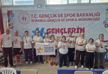 Kapalı bir spor salonunda, “T.C. Gençlik ve Spor Bakanlığı İstanbul Gençlik ve Spor İl Müdürlüğü” yazılı bir pankart önünde bir grup sporcu yan yana duruyor. Üzerlerinde beyaz tişörtler olan sporcuların bazılarının boynunda madalyalar var, bazıları da ellerinde katılım belgeleri tutuyor. Ortada bir ekip, “Tomurcuk Yıldızlar Spor Kulübü” yazılı pankart açmış. Genel atmosfer, bir yarışma sonrası toplu fotoğraf ve başarı anı hissi veriyor.