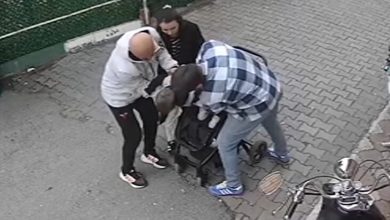 Güvenlik kamerası açısından çekilmiş görüntüde, üç kişi küçük bir çocuğun etrafında toplanmış durumda. Yetişkinlerden biri çocuğa müdahale ederken diğerleri destek oluyor. Kaldırım kenarında geçen bu an, acil bir duruma yapılan hızlı müdahaleyi yansıtıyor.