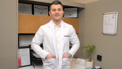 Görselde, Özel Sağlık Hastanesi Fizik Tedavi ve Rehabilitasyon Uzmanı Dr. Arman Öztürk ayakta duruyor ve elleri üniformasının cebinde.
