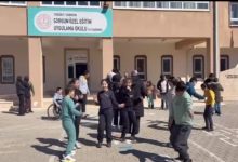 Bir okul bahçesinde, önünde “Sorgun Özel Eğitim Uygulama Okulu” tabelası bulunan binanın girişinde öğrenciler bir araya gelmiş. Çocuklar ve gençler grup halinde oyun oynayıp dans ederken, arka planda öğretmenler ve diğer öğrenciler de onları izliyor. Ortam hareketli, neşeli ve sosyal bir etkinlik havası taşıyor.