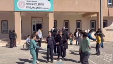 Bir okul bahçesinde, önünde “Sorgun Özel Eğitim Uygulama Okulu” tabelası bulunan binanın girişinde öğrenciler bir araya gelmiş. Çocuklar ve gençler grup halinde oyun oynayıp dans ederken, arka planda öğretmenler ve diğer öğrenciler de onları izliyor. Ortam hareketli, neşeli ve sosyal bir etkinlik havası taşıyor.