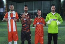 Yan yana sahada duran dört Adana İşitme Engelliler Spor Kulübü sporcusu, formalarında beIN SPORTS göğüs reklamı yazısını işaret ederek poz veriyor.