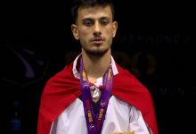 Milli Para Tekvando sporcusu Yusuf Yünaçtı, sırtında Türk bayrağı asılı olarak kadraja yansıyor.