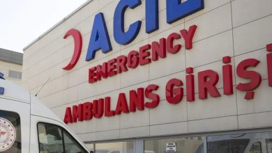 Bir hastanenin acil girişinde beyaz bir ambulans duruyor.