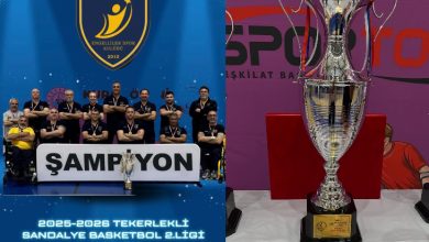 Görselde, Brew Mood 9 Eylül Engelliler Spor Kulübü oyuncuları ve teknik ekibi “ŞAMPİYON” yazılı pankartın arkasında toplu halde poz veriyor. Arka planda kulübün logosu yer alırken, ön planda ise kazanılan büyük kupa dikkat çekiyor. Görsel, takımın 2025-2026 sezonu Tekerlekli Sandalye Basketbol 2. Ligi şampiyonluğunu kutladığını yansıtıyor.