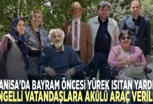 Altı kişilik bir grup var; iki kişi tekerlekli sandalyede, diğerleri ayakta ve hepsi birlikte poz veriyor.