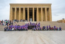 Anıtkabir’in önünde bir araya gelen SMA’lı bireyler, aileleri ve destekçileri toplu fotoğraf çektiriyor. Katılımcıların çoğu mor renkli kıyafetler giyerken, bazı bireyler tekerlekli sandalye kullanıyor. Görsel, birlik, dayanışma ve toplumsal farkındalık mesajı taşıyor.