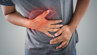 Bir erkek sağ üst karın bölgesini tutarken, karaciğer çevresinde ağrı ve hassasiyeti temsil eden kırmızı bir vurgu bulunan pankreas organının görseli görülüyor.