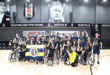 Görsel, Beşiktaş’ın Süleyman Seba Spor Salonu’nda düzenlenen organizasyonun ardından, kupaları ve madalyalarıyla büyük bir coşku içinde zaferlerini kutlayan tekerlekli sandalye basketbol takımının, Fenerbahçe bayrağı eşliğinde toplu hatıra pozu verdiği gurur dolu bir anı yansıtmaktadır.