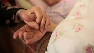 Görselde, yatakta uzanan yaşlı bir kişinin elini tutan başka bir kişi görülüyor. Yakın plandaki bu temas; bakım, destek ve duygusal dayanışma hissini öne çıkarırken, yaşlı bireylerin sosyal destek ihtiyacını çağrıştıran sakin ve içten bir anı yansıtıyor.