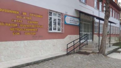 Bir özel eğitim okulunun giriş cephesi görülüyor. Bina önünde engelli erişimine uygun rampa ve merdiven yer alırken, duvarda okul tabelası ve motivasyon amaçlı bir söz bulunuyor. Görsel, özel eğitim hizmeti veren bir eğitim kurumunun dış görünümünü yansıtıyor.
