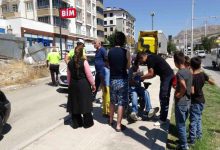 Akülü sandalyede bulunan yayanın etrafında vatandaşlar ve polis memurları bulunuyor.