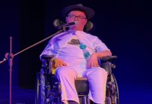 Efe Samet Aslan, sade sahne düzeninde, mikrofon eşliğinde performansını sergiliyor.
