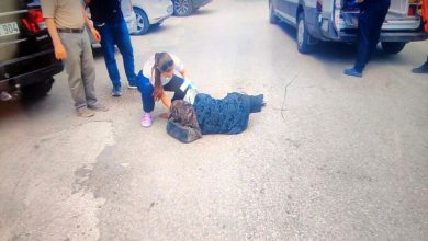 Sağlık personeli kadın, yerde uzanan kadına müdahale ediyor.