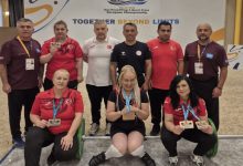 Madalya kazanan sporcular ile teknik heyet bir arada poz veriyor.