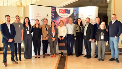 Atabay Biyoteknoloji ekibi, TÜBİTAK ve Avrupa Birliği logolarının yer aldığı bilimsel temalı büyük bir tanıtım panosu önünde toplu halde poz veriyor. On iki kişilik ekip, resmi bir toplantı veya proje etkinliği kapsamında bir araya gelmiş izlenimi veriyor; ortam ferah, kurumsal ve profesyonel bir salon görünümünde.