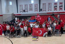 Kadrajın merkezinde, tekerlekli sandalyedeki Türkiye milli takım oyuncuları ve teknik ekip yer alıyor.