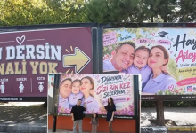 Görselde, sokak üzerindeki reklam panolarına (billboard) asılmış aile fotoğrafları ve bu panoların önünde poz veren mutlu bir aile yer almaktadır. Panoların üzerinde çeşitli sevgi dolu yazılar ve illüstrasyon detayları dikkat çekmektedir.