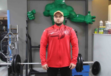 Görselin üst bölümünde, spor salonunda ağırlık çalışma istasyonunun önünde dimdik durarak kararlı bir bakışla doğrudan kameraya odaklanan görme engelli milli sporcu Şimşek yer alıyor. Başında bej renkli bir beyzbol şapkası, üzerinde göğsünde Türk bayrağı amblemi bulunan kırmızı milli takım fermuarlı üstü ve altında siyah spor pantolonu bulunuyor. Sporcunun önünde halter barı ve ağırlık plakaları, hemen arkasındaki duvarda ise geometrik formda tasarlanmış yeşil dev bir çizgi roman karakteri figürü (Hulk) ile spor salonu ekipmanları görülüyor.