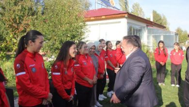 İşitme Engelliler Kadın Güreş Milli Takımı sporcuları, İşitme Engelliler Spor Federasyonu Başkanı Dursun Gözel ile iletişim kurarken samimi ve gülümseyen anlar görsele yansıyor.