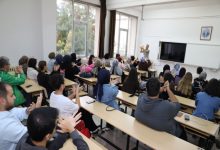 Sınıfta öğretmenin yönlendirmesiyle sıralarında oturan öğrenciler, elleriyle işaret dili terimi yapmakta ve etkileşimli bir öğrenme ortamı oluşturmaktadır.