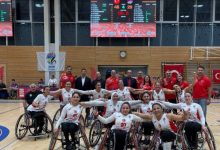 Tekerlekli Sandalye Basketbol Kadın Millî Takımı oyuncuları birbirlerinin omuzlarını tutarak poz veriyor.